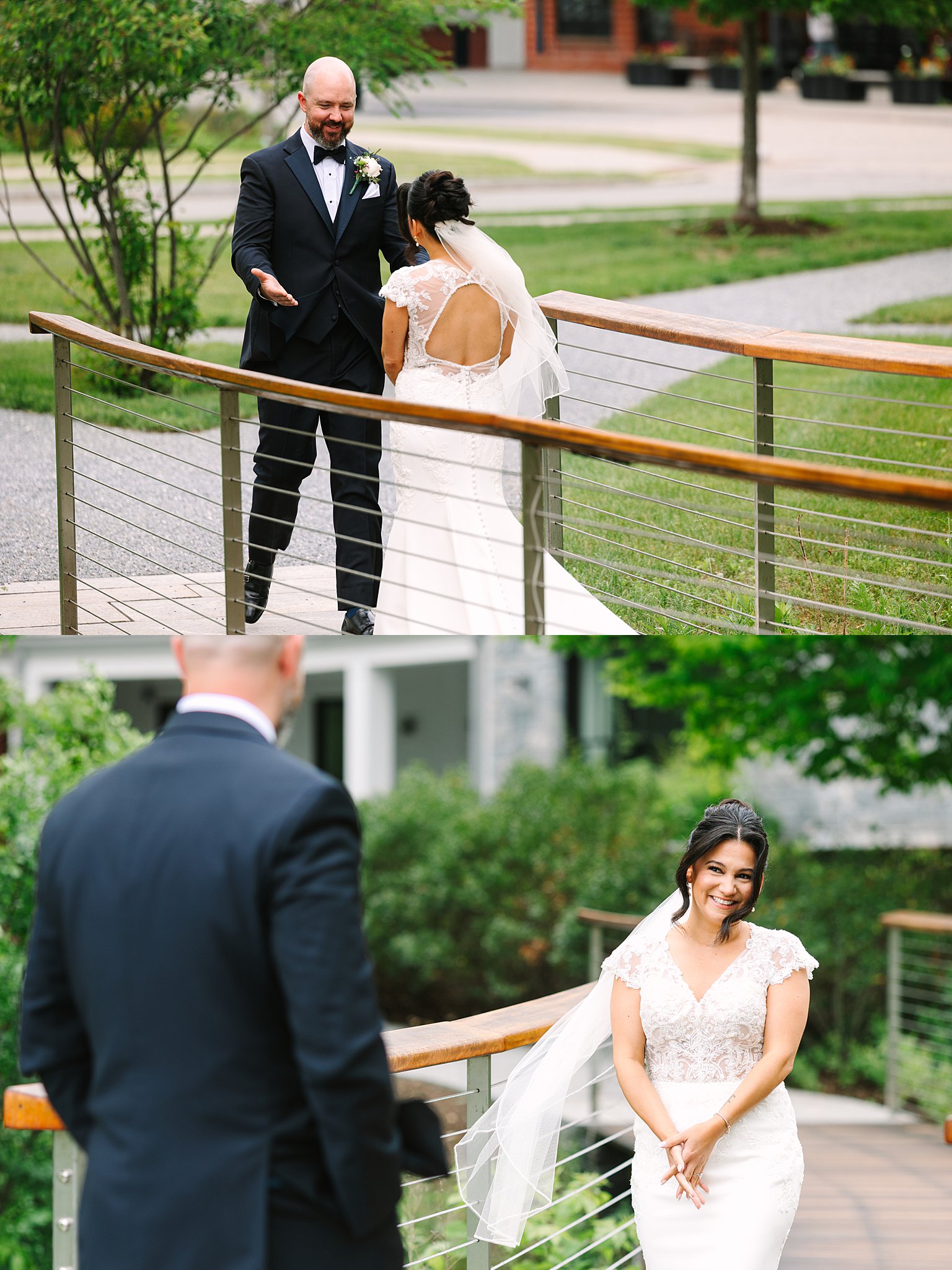 A bride in a white gown and veil surprises a man in a black tuxedo outdoors. He reacts with joy, and she smiles warmly, standing on a wooden bridge surrounded by greenery.