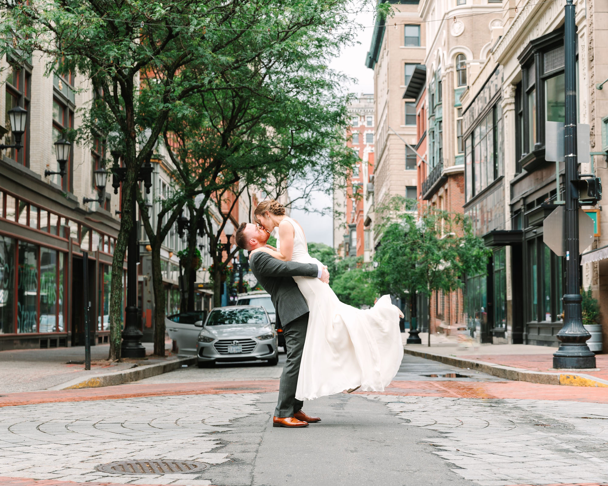 groom lifts his bride at a Providence RI intersection