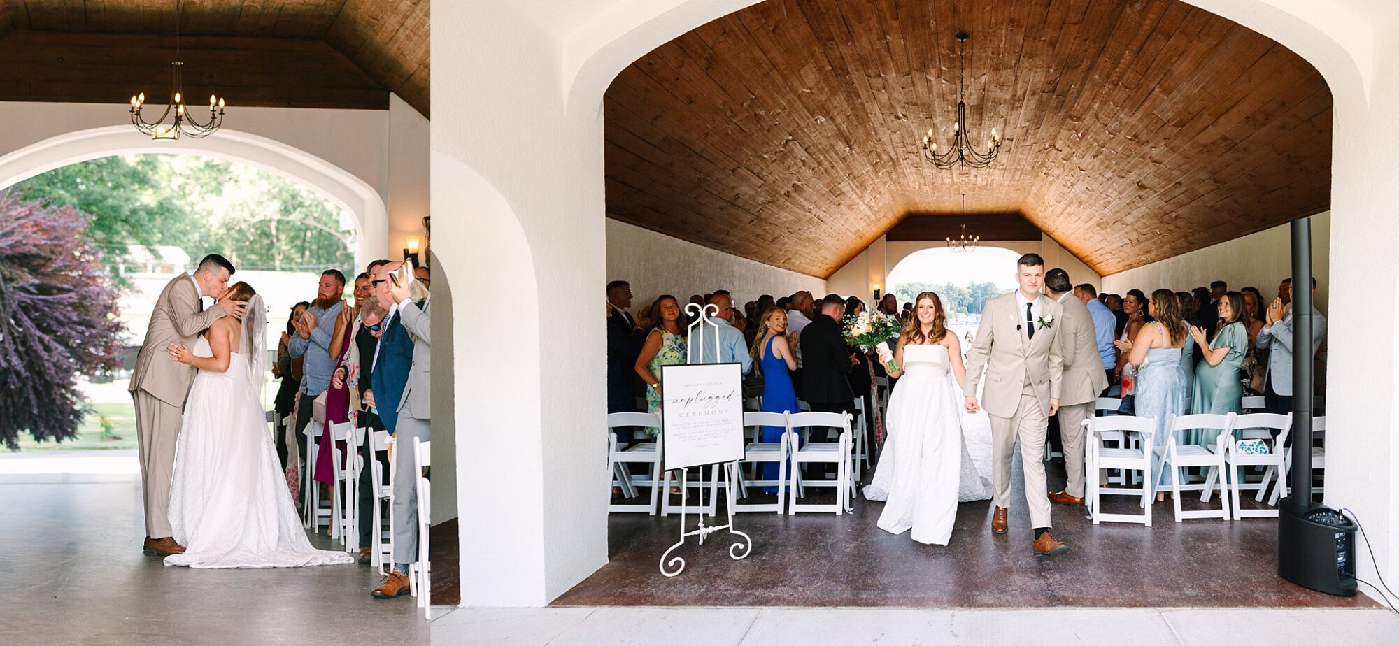 A bride and groom kiss at the end of their wedding ceremony, then walk hand-in-hand down the aisle smiling as guests stand and applaud in a bright, wooden-ceilinged venue.