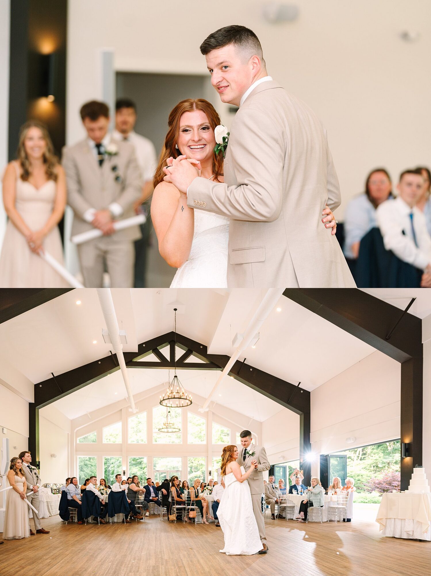 A bride and groom share their first dance at their wedding reception in a bright, spacious hall with large windows. Guests watch and smile from their seats in the background.