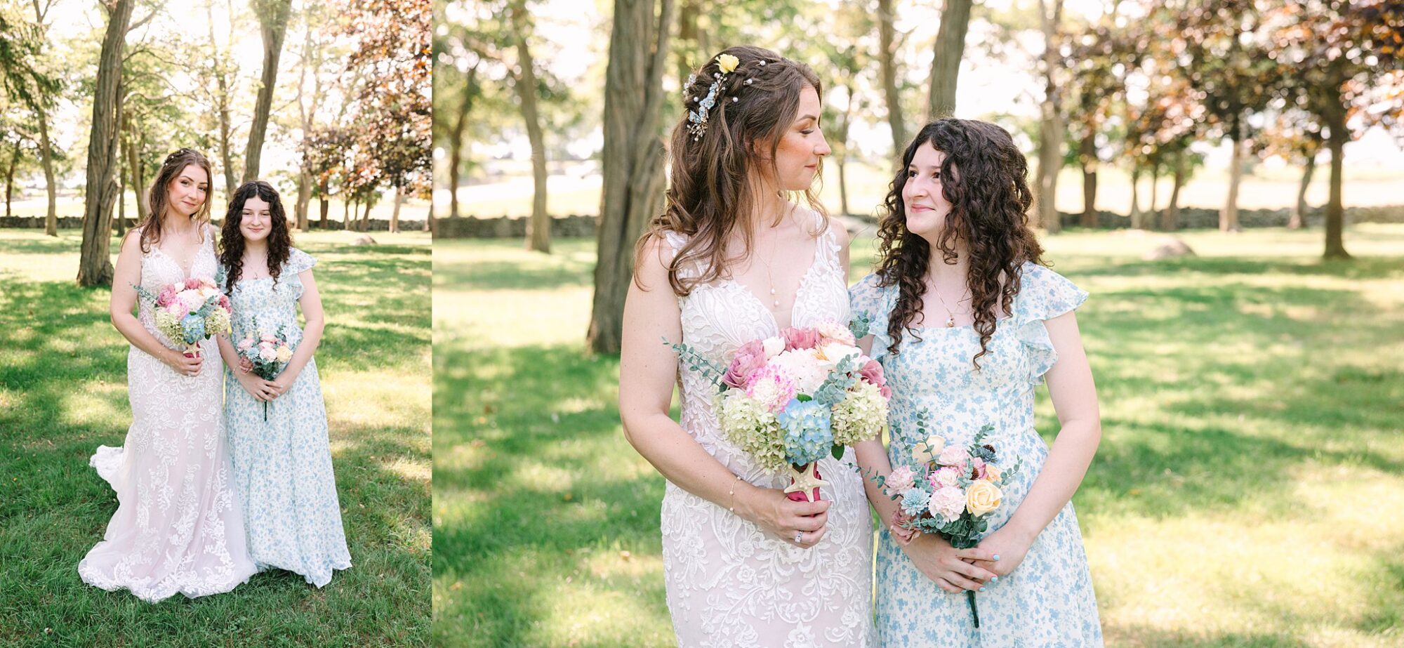 Two women in light dresses stand together in a sunlit grassy park, holding colorful flower bouquets and smiling at each other, surrounded by trees.