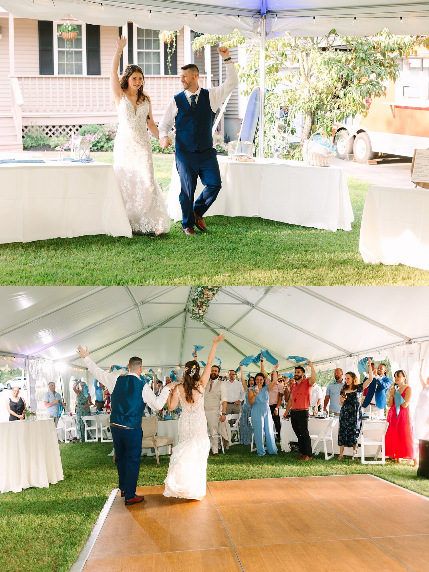A bride and groom joyfully enter a tented wedding reception, holding hands with arms raised, while guests cheer and wave napkins in celebration.