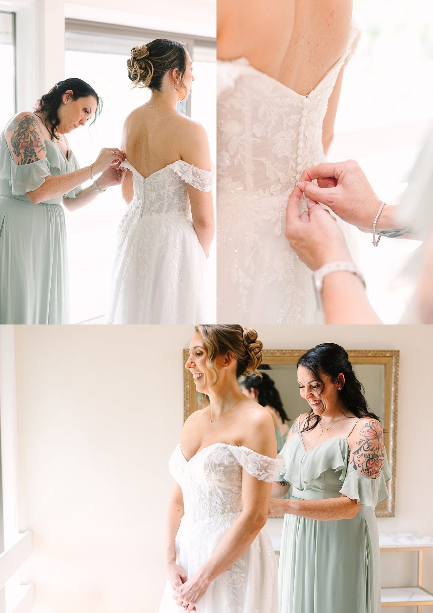 A bridesmaid in a sage green dress helps a bride in an off-shoulder white gown button up her dress. Both women are smiling in a bright, softly lit room.